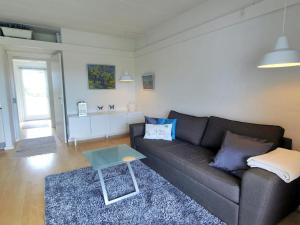 ein Wohnzimmer mit einem Sofa und einem Tisch in der Unterkunft Apartment Magnus - 6km from the sea in Bornholm by Interhome in Åkirkeby