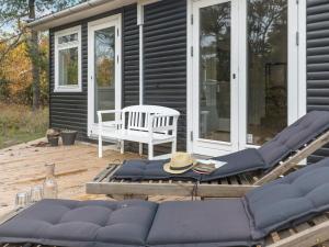 a deck with chairs and a bench on a house at Holiday Home Aida - 400m from the sea in Bornholm by Interhome in Rønne