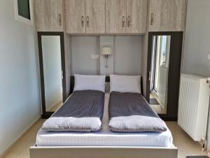una camera con 2 letti e armadi in legno di Horizon /Downtown Penthouse w/ massive terrace a Salonicco