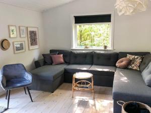 a living room with a couch and a chair at Holiday Home Aida - 400m from the sea in Bornholm by Interhome in Rønne