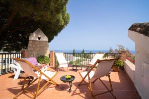 un grupo de sillas y una mesa en un patio en Casa Ancladero Big rooftop terrace, 2 bedroom guesthouse w garden and view en Fuengirola