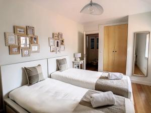 two beds in a room with white walls at FX City Lover by LovelyStay in Funchal