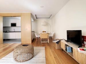 a living room with a table and a television at FX City Lover by LovelyStay in Funchal