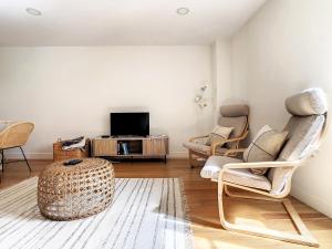 a living room with two chairs and a tv at FX City Lover by LovelyStay in Funchal +14 photos