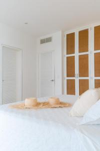 a white bed with two pillows on top of it at Tanusas Retreat & SPA in Puerto Cayo