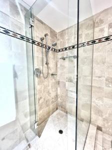 a bathroom with a shower with a glass door at 216 Hastings Street Luxury Apartment walk to beach in Noosa Heads