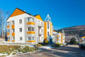 un edificio de apartamentos de color naranja y blanco en Apartament Mysia, en Świeradów-Zdrój