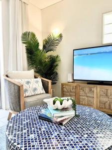 un salon avec une télévision et une table dans l'établissement 311 Hastings Street 2 Bedroom Luxury, à Noosa Heads