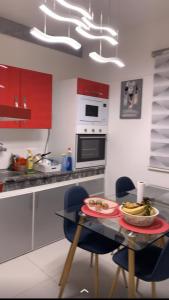 a kitchen with red cabinets and a table with food on it at SO CHIC APPARTEMENT Airport international Rabat-Salé in Salé