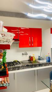 - une cuisine avec des placards rouges et un évier dans l'établissement SO CHIC APPARTEMENT Airport international Rabat-Salé, à Sale