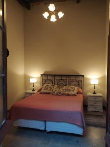 1 dormitorio con 1 cama con 2 mesitas de noche y 2 lámparas en Casa, Ituzaingó 215, en Colonia del Sacramento