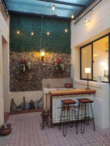 un bar con taburetes en una habitación con una pared de piedra en Casa, Ituzaingó 215, en Colonia del Sacramento