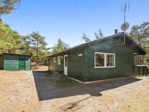 a small green cabin with a green at Holiday Home Michel - 300m from the sea in Bornholm by Interhome in Vester Sømarken
