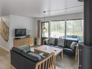 een woonkamer met een bank en een tafel bij Holiday Home Michel - 300m from the sea in Bornholm by Interhome in Vester Sømarken