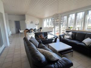 a living room with a leather couch and a table at Holiday Home Lätizia - 300m from the sea by Interhome in Svaneke
