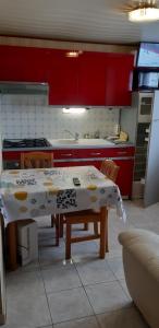cocina con mesa, sillas y armarios rojos en studio pres du lac d'annecy, en Seythenex
