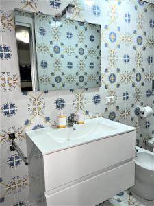 La salle de bains est pourvue d'un lavabo blanc et d'un miroir. dans l'établissement Scalinatella, à Castellammare di Stabia