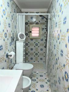 La salle de bains est pourvue de toilettes et de carrelage bleu et blanc. dans l'établissement Scalinatella, à Castellammare di Stabia