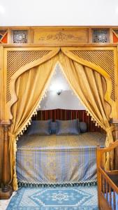 a bedroom with a canopy bed with curtains at Dar El Goulli in Sousse