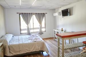 Dormitorio con cama, escritorio y TV en Aparts ALDEA DEL MONTAÑES en Mina Clavero