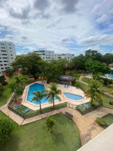 una vista aérea de una piscina con palmeras y edificios en Departamento amoblado en condominio cerrado! Un lugar ideal para instalarse!, en San Lorenzo