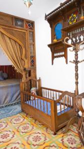 sypialnia z łóżeczkiem dziecięcym i łóżkiem w pokoju w obiekcie Dar El Goulli w Susie