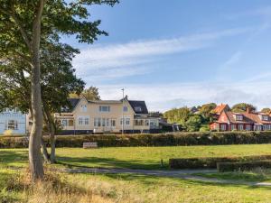 a row of houses in a field with a tree at Apartment Reinhardt - 100m from the sea in Bornholm by Interhome in Allinge