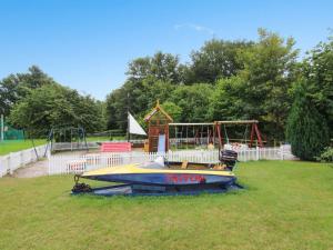 a small boat in a park with a playground at Apartment Syzett - 250m from the sea by Interhome in Neksø