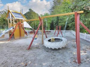a playground with a tire and a swing set at Apartment Syzett - 250m from the sea by Interhome in Neksø