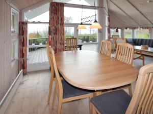 a dining room with a wooden table and chairs at Holiday Home Dagmar - 300m from the sea in Bornholm by Interhome in Hasle