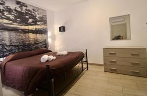 een slaapkamer met een bed en een dressoir met handdoeken bij I Giganti in Cagliari