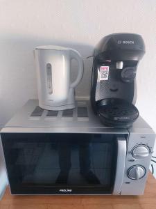 a coffee maker on top of a microwave at Residence d'Anjou - Grand studio avec balcon et parking privatif in Perpignan