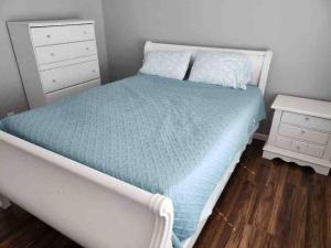 a bedroom with a bed with a blue comforter and a night stand at Lovely Condo on the Water in Kemah