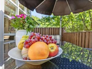a bowl of fruit on a table with a vase of flowers at Holiday Home Dafne - 600m from the sea in Bornholm by Interhome in Hasle