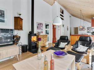 a living room with a table and chairs and a tv at Holiday Home Dafne - 600m from the sea in Bornholm by Interhome in Hasle
