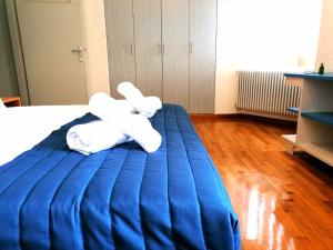 a bed with two white pillows on a blue blanket at EstellApartments in Athens