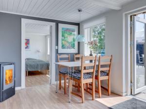 Un comedor con mesa y sillas y chimenea. en Apartment Brawith - 250m from the sea by Interhome, en Neksø