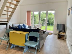 a living room with a bed and a couch at Sea Rose Cottage in Kingsdown