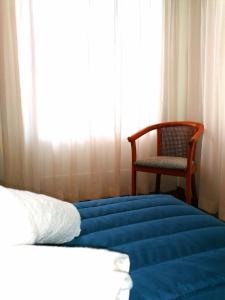 アテネにあるEstellApartmentsのベッドルーム1室(ベッド1台、椅子、窓付)