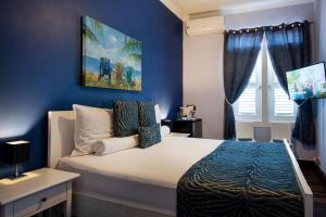 a bedroom with a large bed with blue walls at Villa Amalie & Villa Curiel in Willemstad