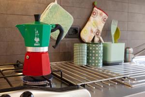 una cafetera roja y verde sobre una estufa en Serena House, en Levanto