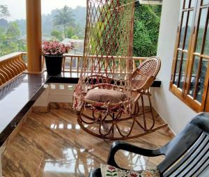 a rocking chair in a room with a balcony at Ivy Cottage in Mananthavady
