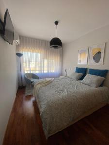 ein Schlafzimmer mit einem großen Bett und einem Stuhl in der Unterkunft Apartamento Central in Braga