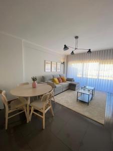 ein Wohnzimmer mit einem Tisch und einem Sofa in der Unterkunft Apartamento Central in Braga