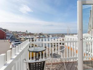 a balcony with a table and chairs and a marina at Holiday Home Momo - 10m from the sea in Bornholm by Interhome in Hasle