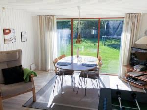 einen Tisch und Stühle im Wohnzimmer mit Fenster in der Unterkunft Holiday Home Harald - all inclusive - 300m from the sea by Interhome in Bøtø By