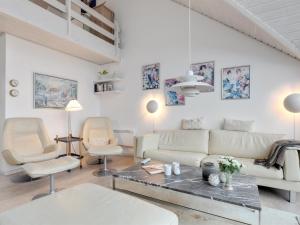 a living room with a white couch and chairs at Holiday Home Armela - 10m from the sea by Interhome in Hasle