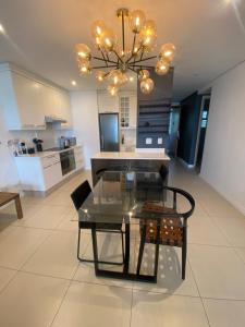 a living room with a glass table and a chandelier at 608 Beacon Rock in Durban