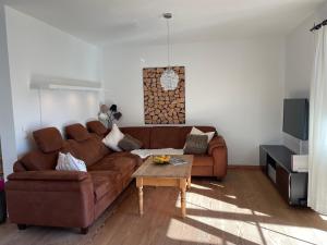 sala de estar con sofá marrón y mesa en Chiemgauer Ferienhaus en Siegsdorf