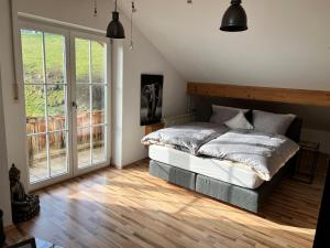 a bedroom with a bed and a large window at Chiemgauer Ferienhaus in Siegsdorf